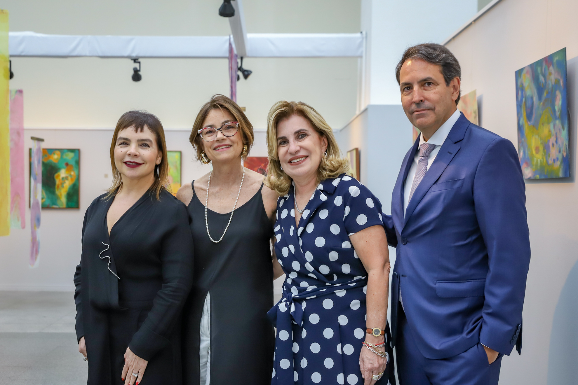 Dra. Marina, Michaela, Dra. Ana Paula e Dr. Marcos posam para foto em frente as obras dispostas no Espaço Cultural