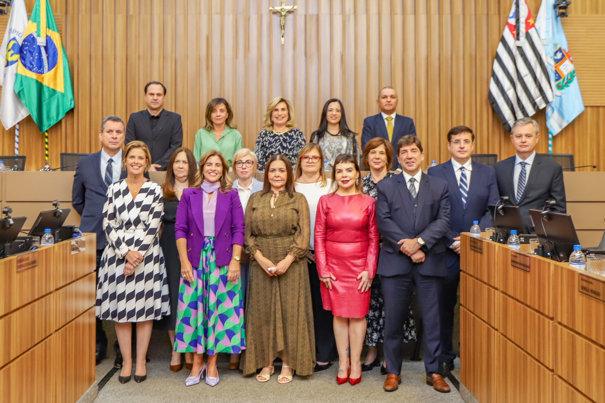 Novos desembargadores posam para foto, todos de pé, em frente a mesa alta, composta por Dra. Ana Paula e demais integrantes