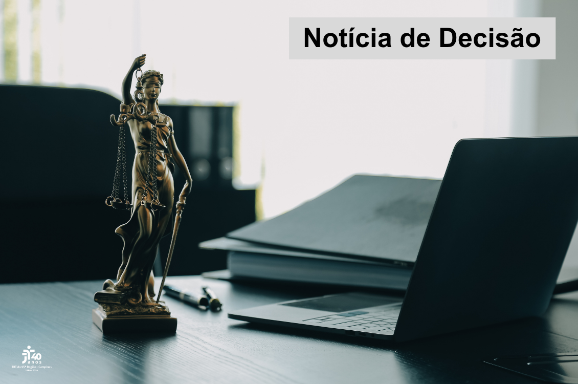 estatua da justiça, um computador e papéis sobre uma mesa