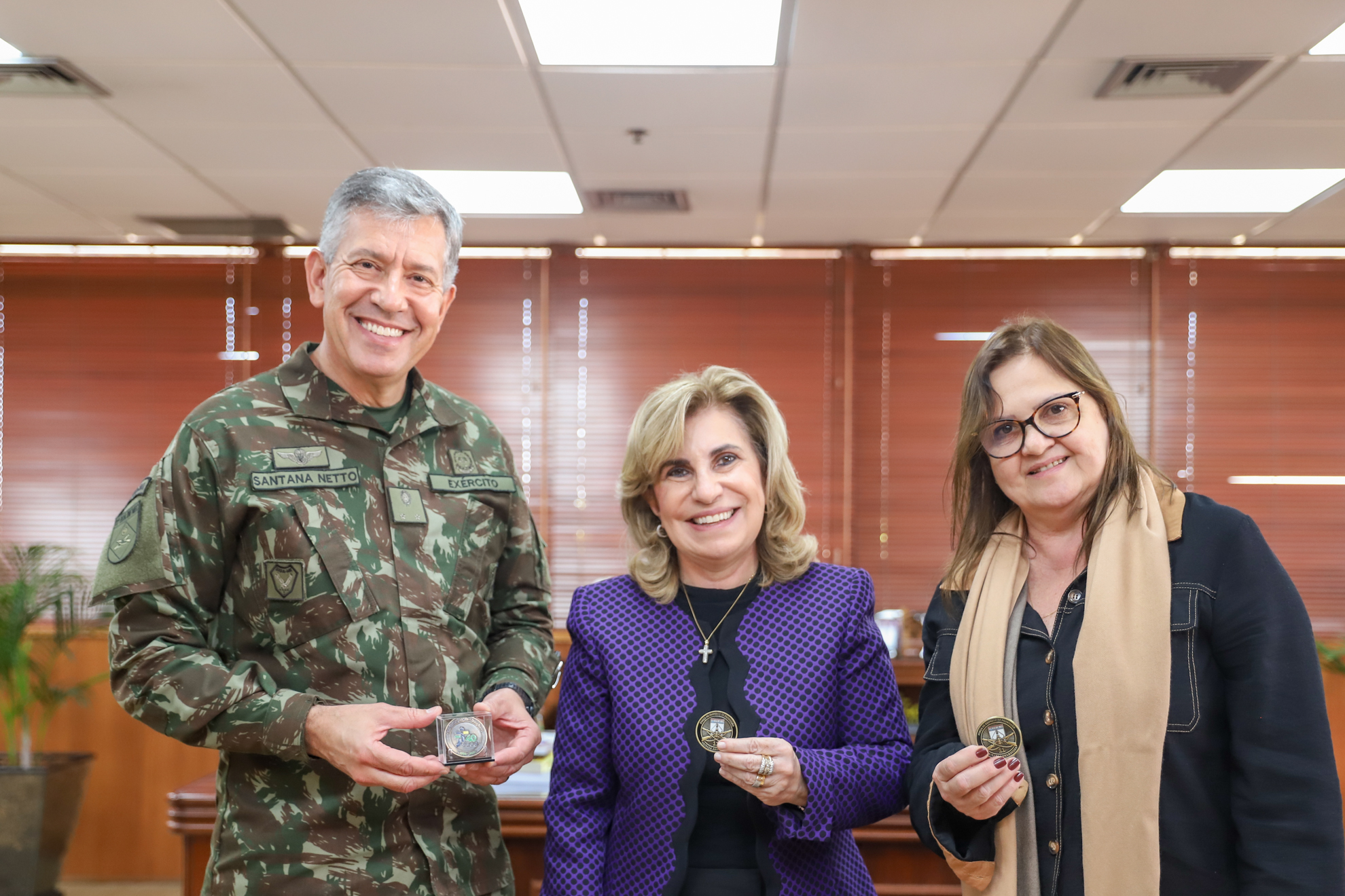 Duas mulheres e um homem posam para a foto.